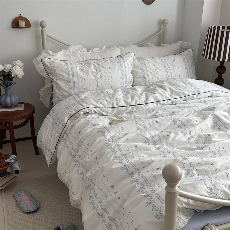 white floral ruffle cotton bedding set on bed with delicate blue pattern