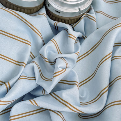 Blue striped bedding set with thin lines on white and a dark brown solid reverse