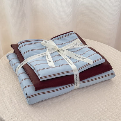 Blue striped bedding set with thin lines on white and a dark brown solid reverse