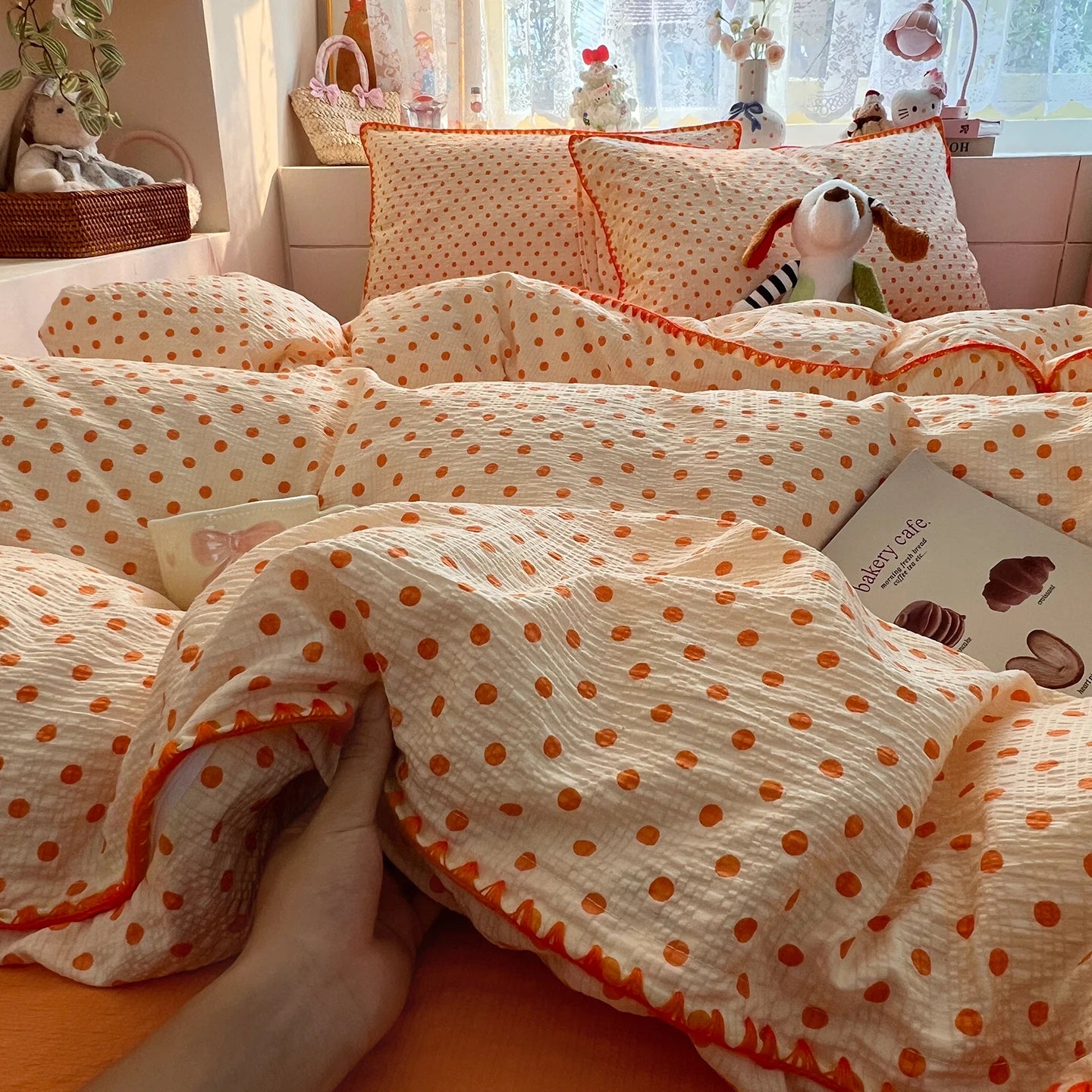 Cream Orange Dot polka dot bedding set with braided trim styled on a bed