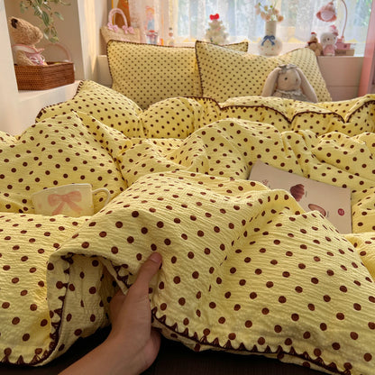 Butter Cocoa Dot polka dot bedding set with braided trim styled on a bed