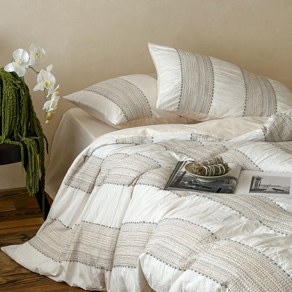Ivory woven-stripe cotton duvet cover set styled with orchids