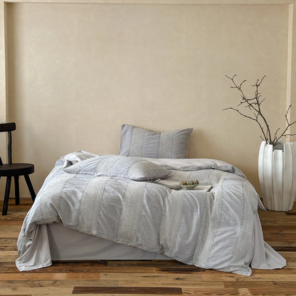 Light gray woven cotton duvet cover set on a minimalist bed
