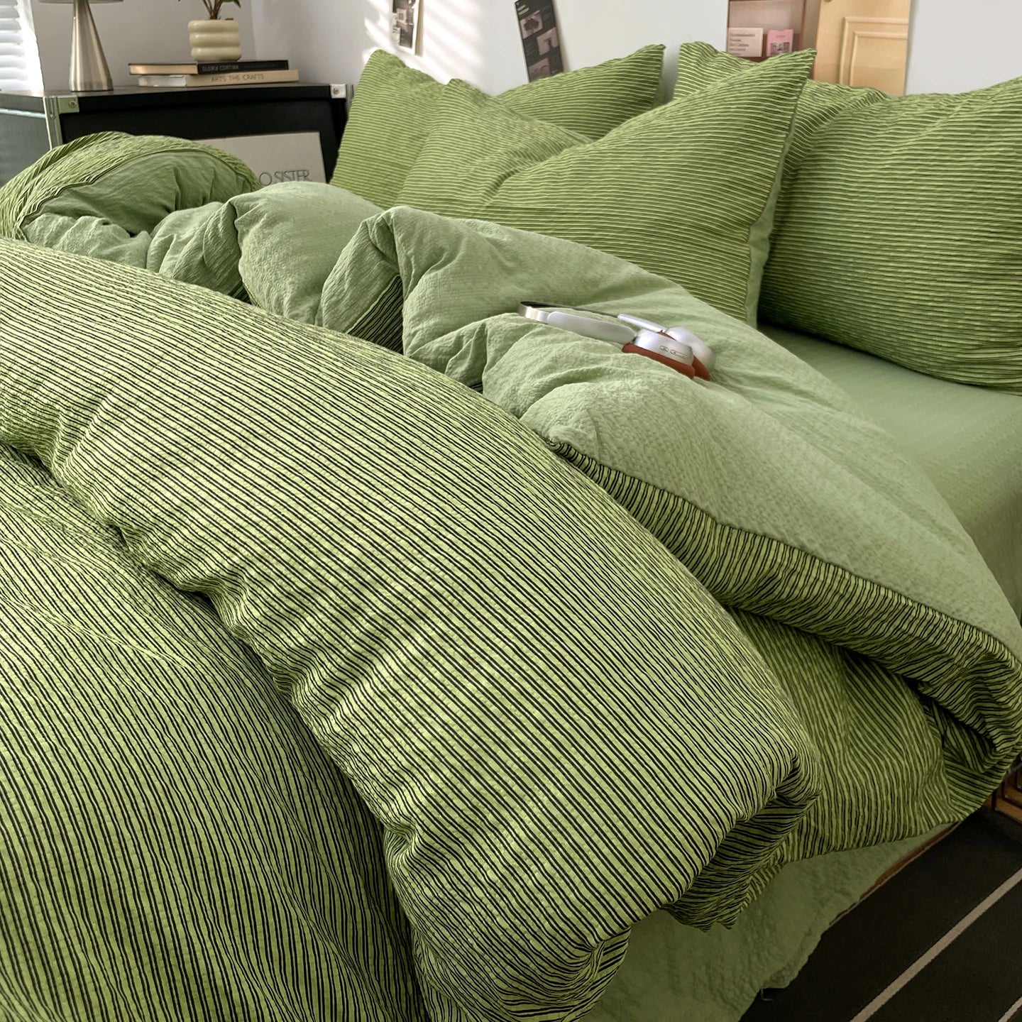 Olive Green textured stripe bedding set styled on a bed with matching pillows