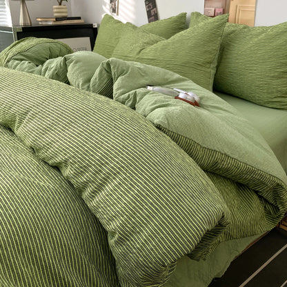 Olive Green textured stripe bedding set styled on a bed with matching pillows