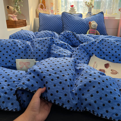 Cobalt Black Dot polka dot bedding set with braided trim styled on a bed
