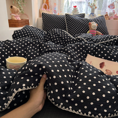 Black Cream Dot polka dot bedding set with braided trim styled on a bed