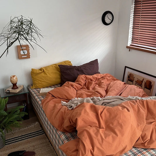 rust orange solid cotton bedding set on bed with yellow and brown pillows