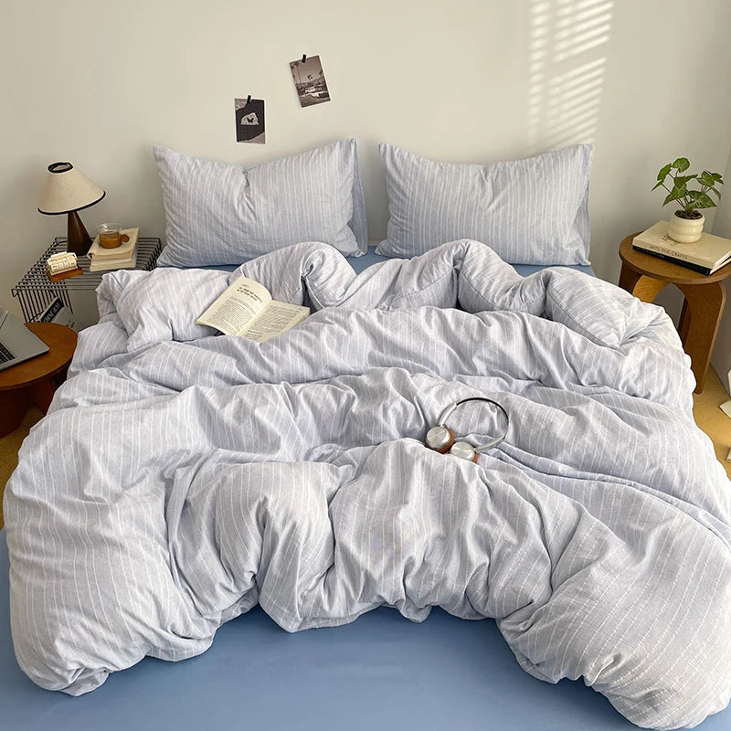 Pale Grey pinstripe bedding set with blue sheet styled on a bed