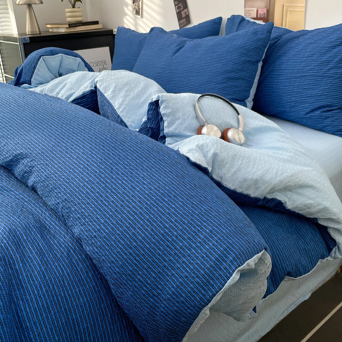 Royal Blue textured stripe bedding set with pale blue reverse styled on a bed