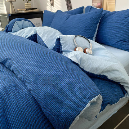 Royal Blue textured stripe bedding set with pale blue reverse styled on a bed