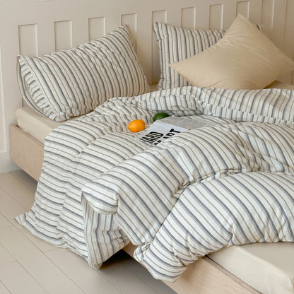 Khaki gray pinstripe cotton bedding set on a white bed frame