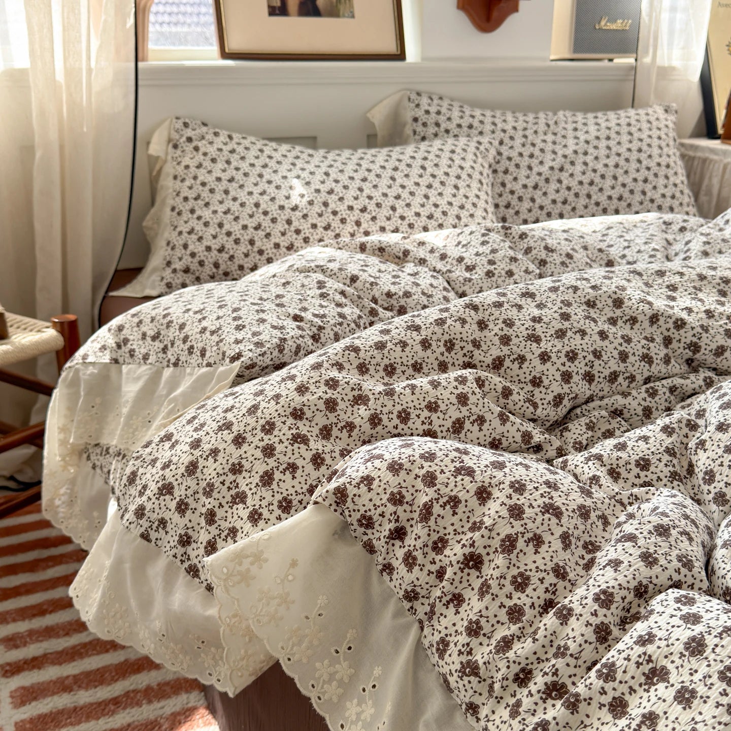 Sepia Bloom floral ruffle bedding set with white lace trim styled on a bed