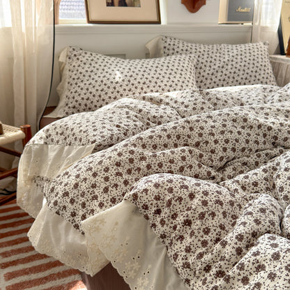 Sepia Bloom floral ruffle bedding set with white lace trim styled on a bed