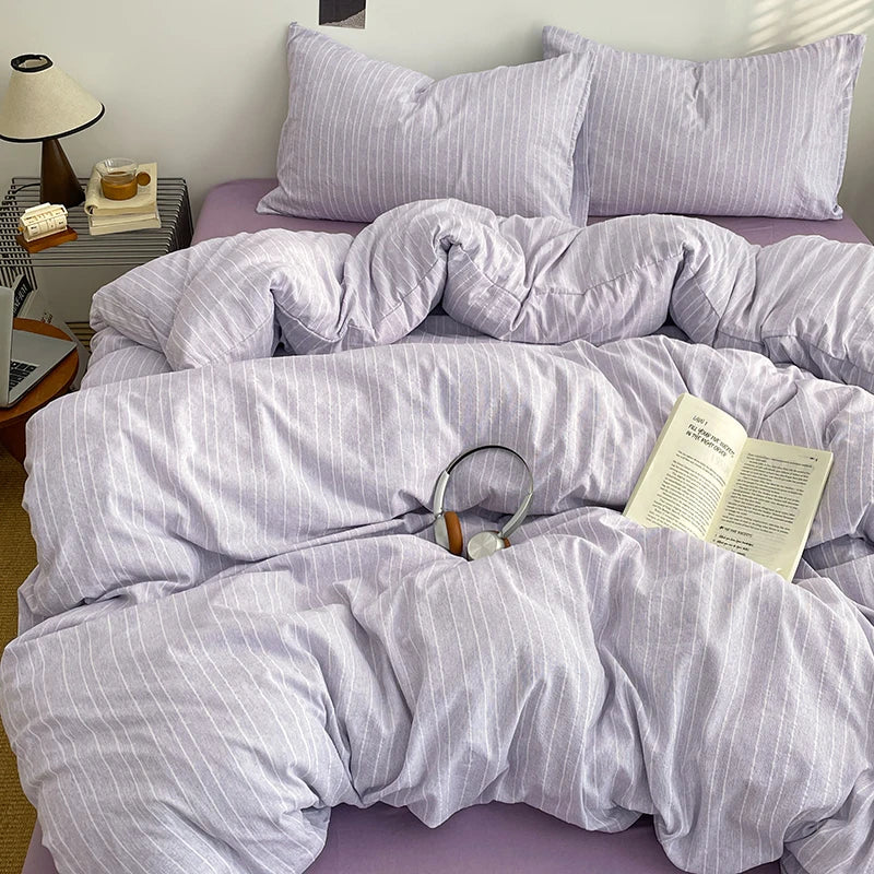 Lilac Grey pinstripe bedding set styled on a bed with matching pillows