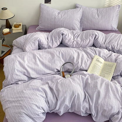 Lilac Grey pinstripe bedding set styled on a bed with matching pillows