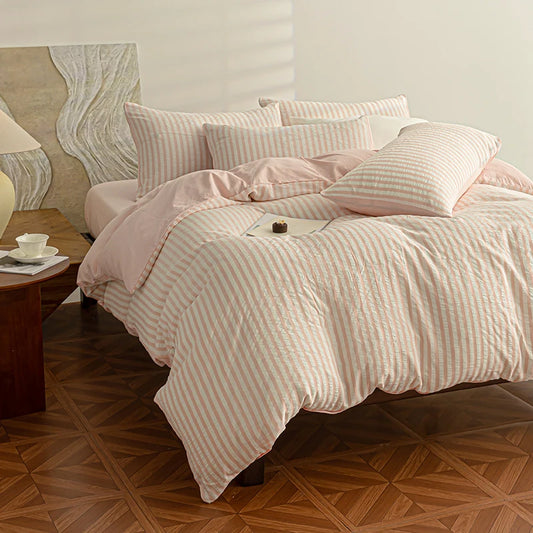 Blush Pink seersucker bedding set styled on a bed with matching pillows