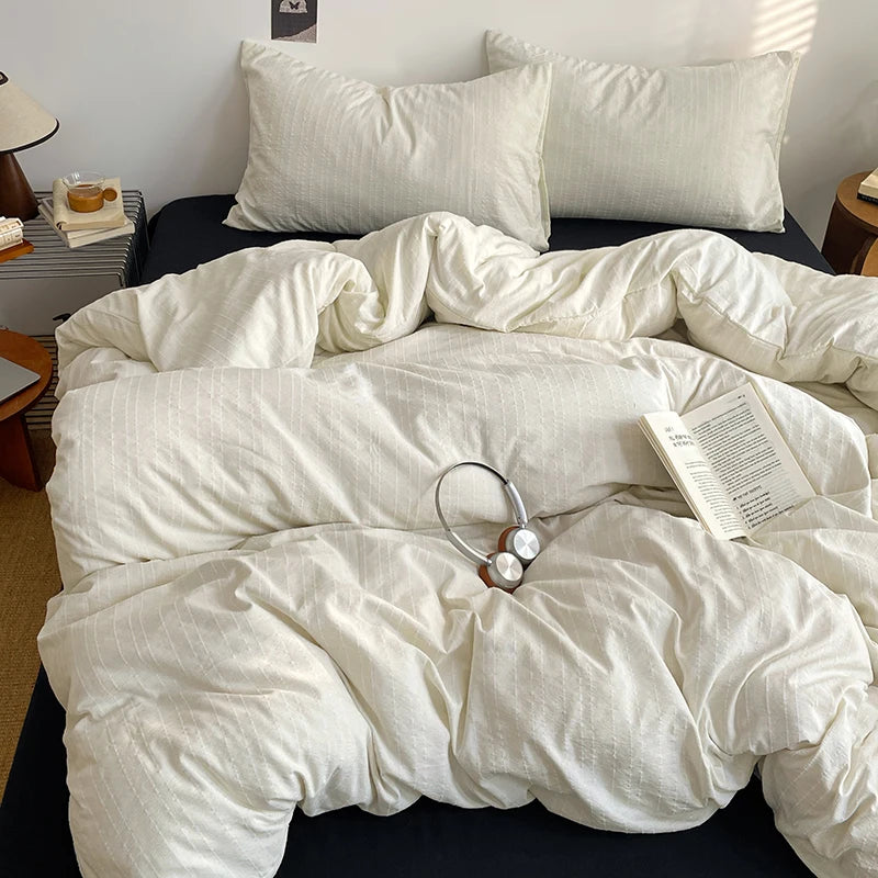 Ivory White pinstripe bedding set with navy sheet styled on a bed