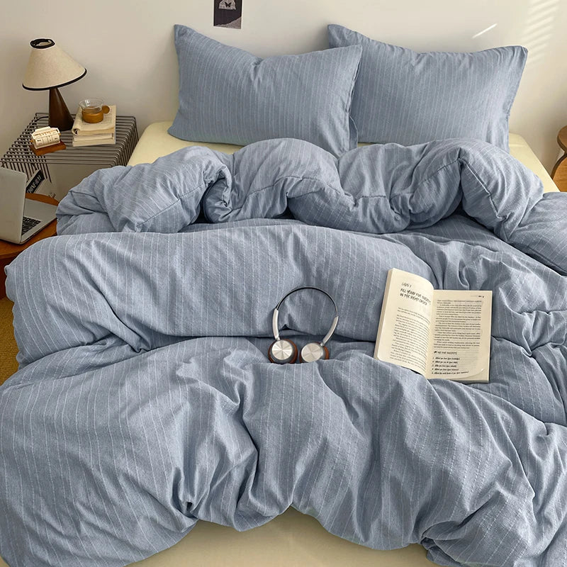 Dusty Blue pinstripe bedding set styled on a bed with matching pillows