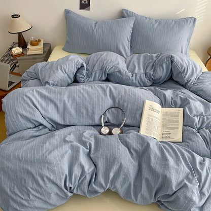 Dusty Blue pinstripe bedding set styled on a bed with matching pillows
