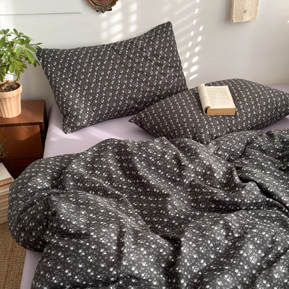 Charcoal Ditsy floral bedding set with solid lilac reverse styled on a bed