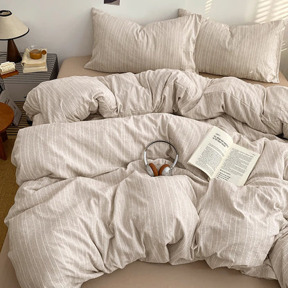 Oatmeal pinstripe bedding set styled on a bed with matching pillows