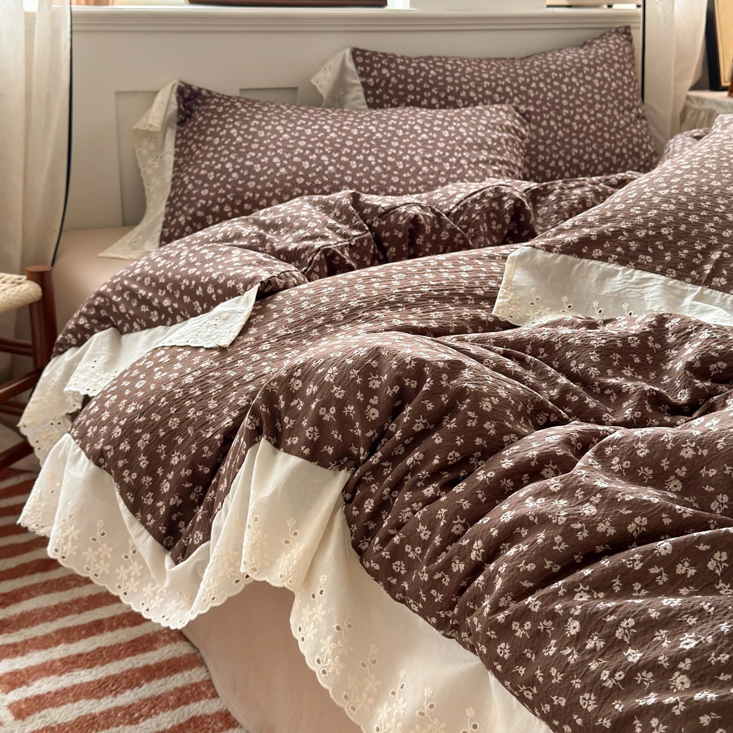 Cocoa Bloom floral ruffle bedding set with white lace trim styled on a bed