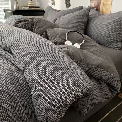 Charcoal Grey textured stripe bedding set styled on a bed with matching pillows