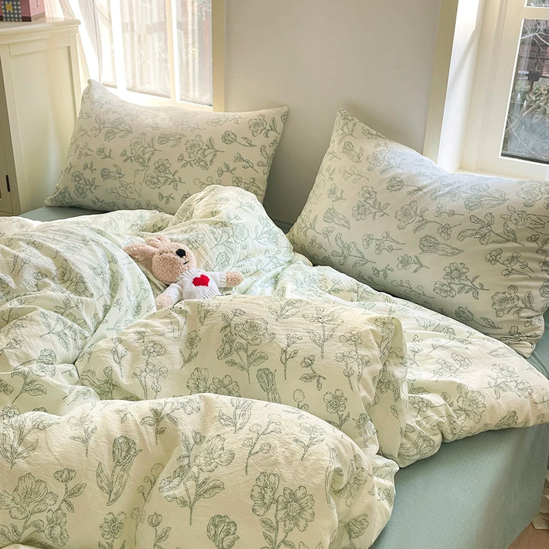Sage Garden botanical floral bedding set in sage line print on cream styled on a bed