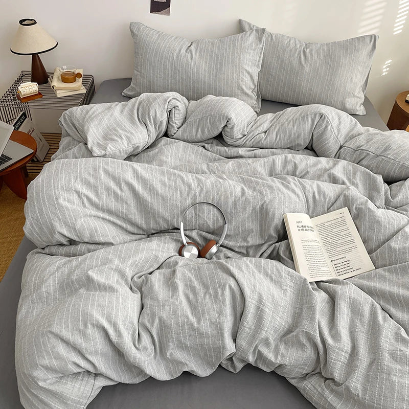Heather Grey pinstripe bedding set styled on a bed with matching pillows