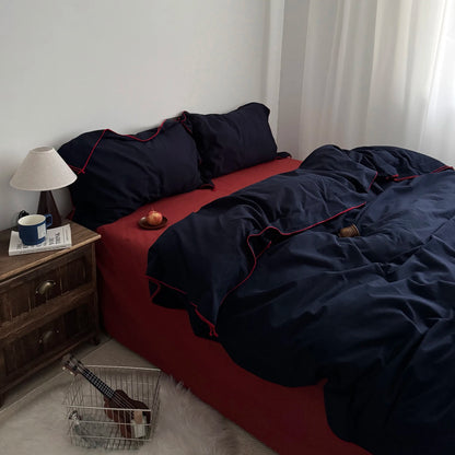 Bold navy and red cotton bedding set on a modern bed