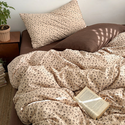 Almond Meadow ditsy floral bedding set with solid brown pillow styled on a bed