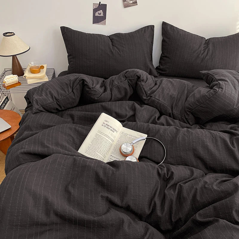 Charcoal Black pinstripe bedding set styled on a bed with matching pillows