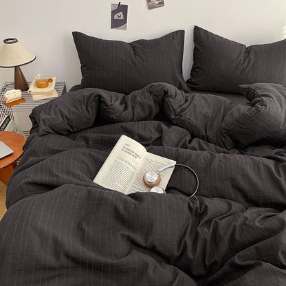 Charcoal Black pinstripe bedding set styled on a bed with matching pillows