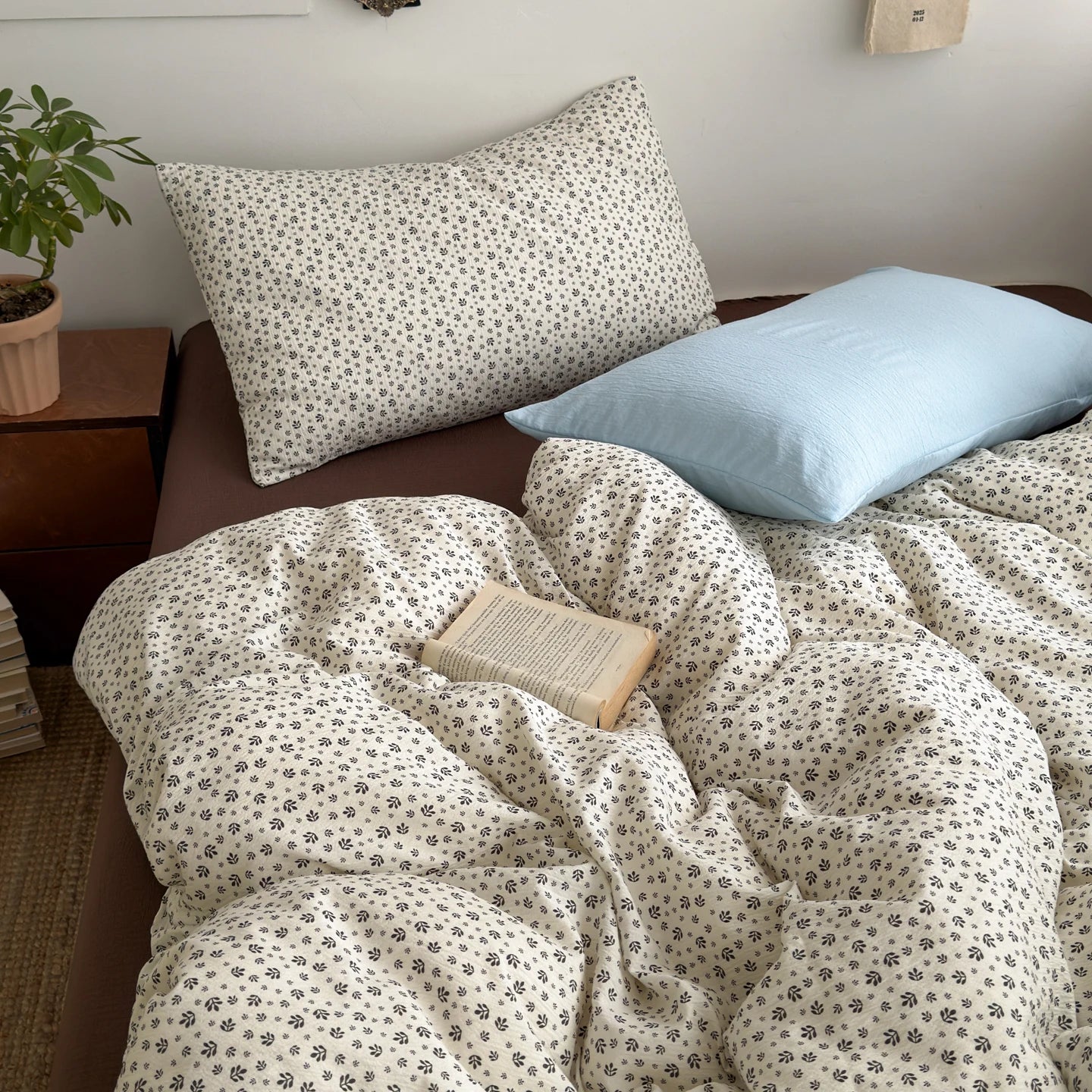 Ivory Sprig ditsy floral bedding set with solid blue pillow styled on a bed