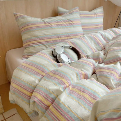 Cream bedding set with colorful horizontal rainbow stripes in yellow, pink, and blue for cheerful bedroom decor