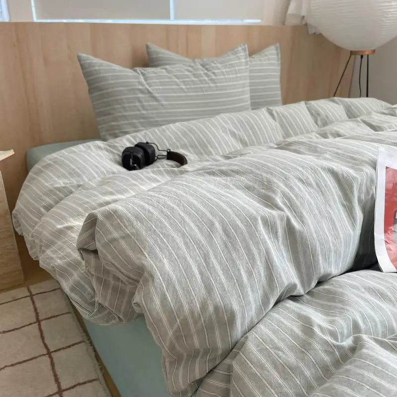 Sage green bedding set with white pinstripes in minimalist style for a calm and modern bedroom