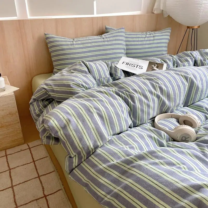 Slate blue bedding set with green and white stripes in a minimalist bedroom setting