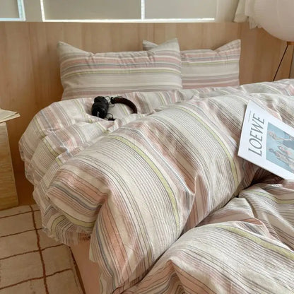 Cream bedding set with blush pink, olive green, and pastel lavender multicolor stripes on soft cotton fabric