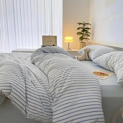 white bedding set with blue stripes on bed