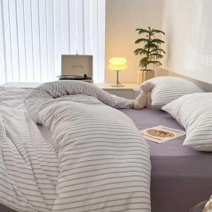 white bedding set with lavender stripes on bed