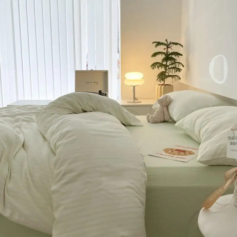 white bedding set with mint green stripes on bed