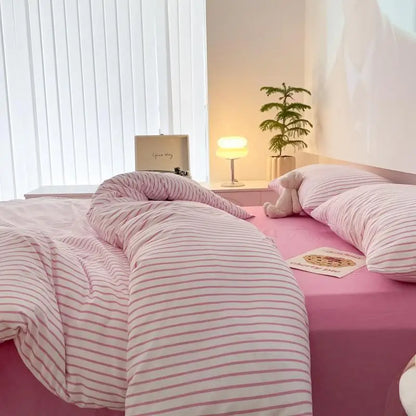 white bedding set with pink stripes on bed