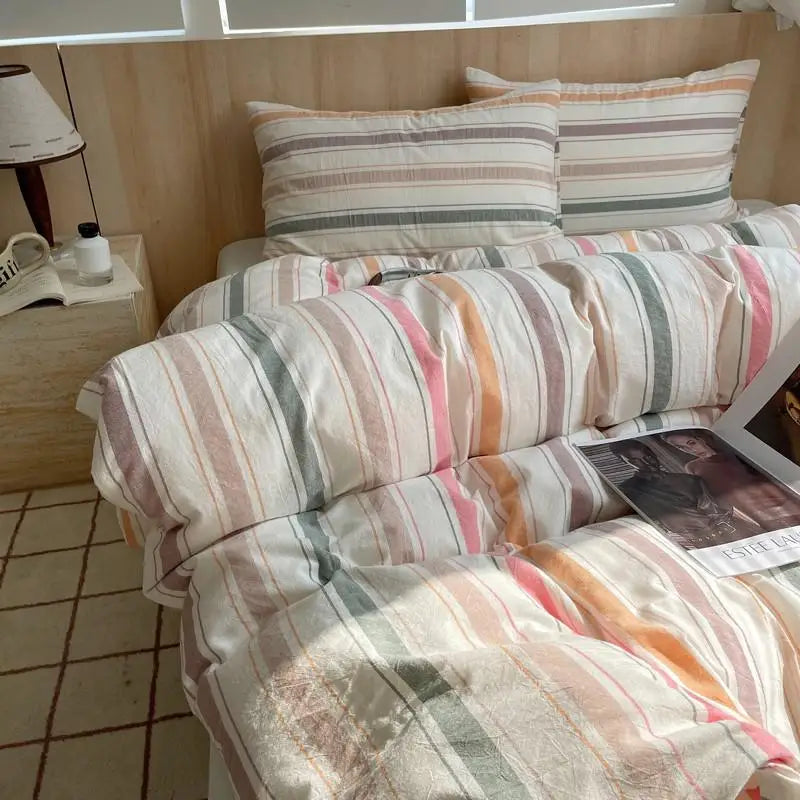 White bedding set with multicolor earth tone stripes in orange, green, coral, and beige